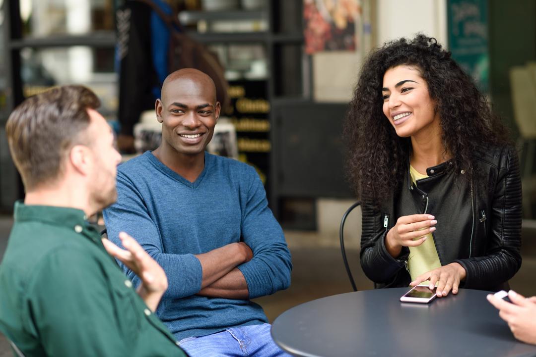 A group of friends sitting in cafe and having a chat.