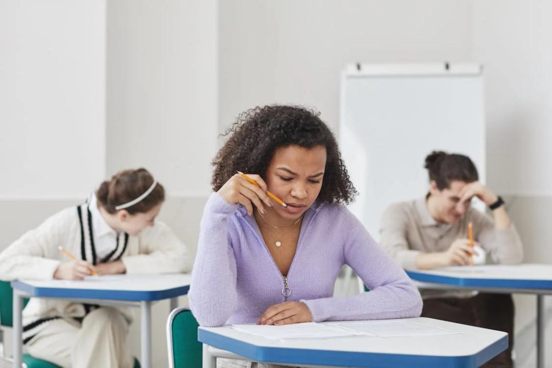 woman looking at test paper on desk