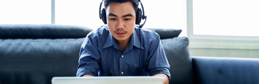 a man using a laptop and a headphone