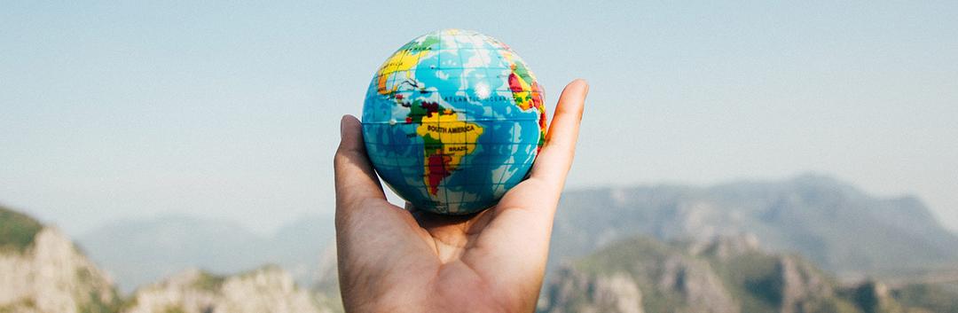 a man holding a mini globe