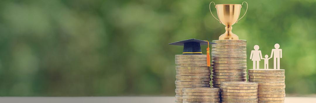 Multiple stacks of coins with a graduation hat, a trophy and a paper cut out of a little family.